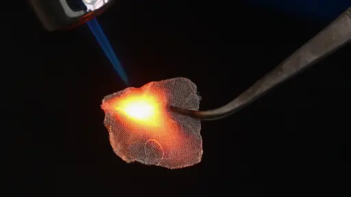 Close up of material being heated with flame.