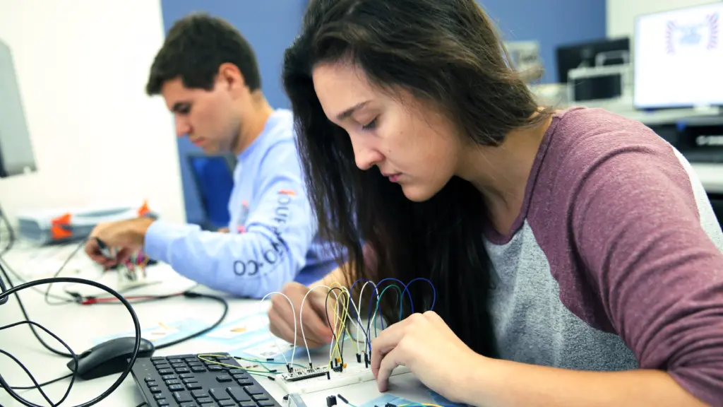 Close up of female student working with electronics in classroom