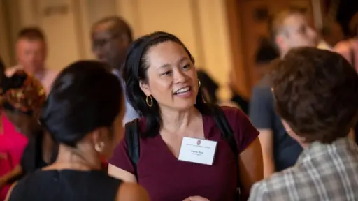 A faculty member wears a nametag while in conversation at the faculty of color reception