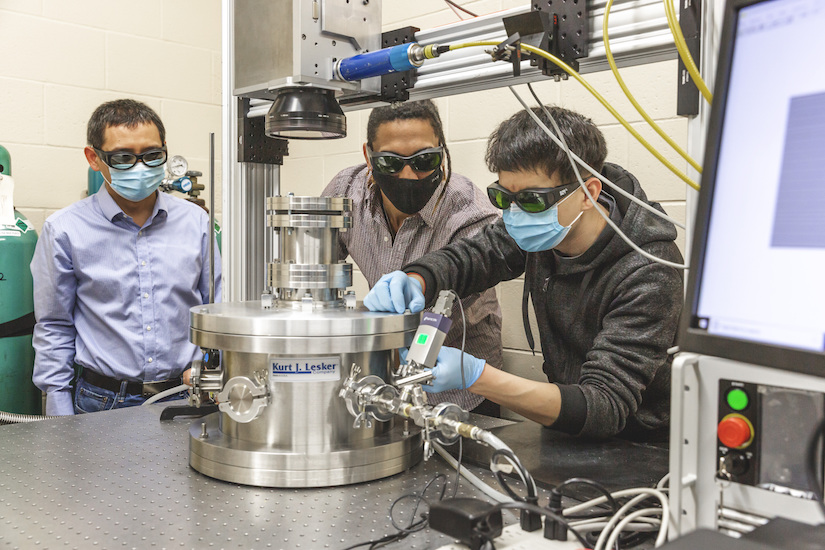 Lianyi Chen and PhD students Luis Escano and Minglei working in the lab