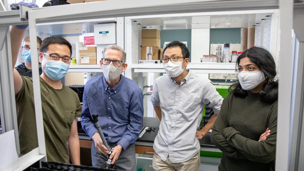 From left, Seunghyeon Jung, a biological systems engineering PhD student, discusses an idea with Rob Anex, professor of biological systems engineering, Bu Wang, an assistant professor of civil and environmental engineering, and Keerthana Sreenivasan, a graduate student in civil and environmental engineering, in a lab at the Wisconsin Energy Institute at UW–Madison.