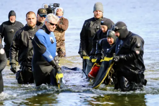 Divers retrieve the canoe from Lake Mendota