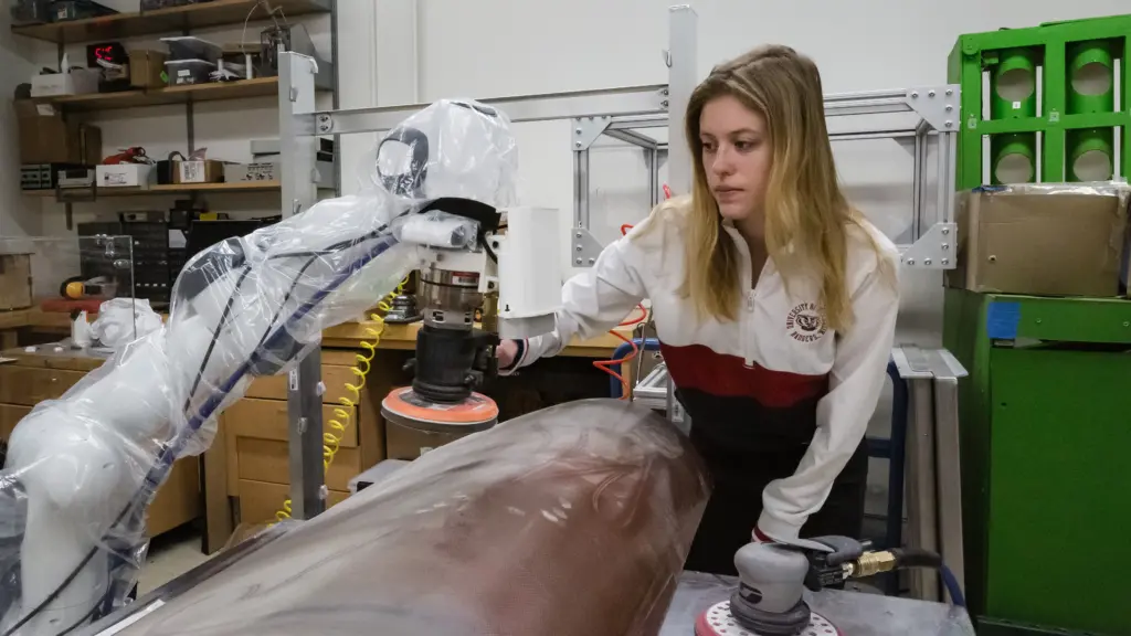 Grad student Anna Konstant examines a collaborative robot