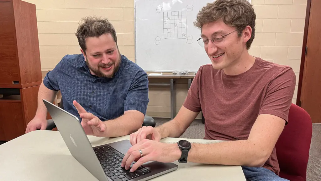 Yonatan Mintz and PhD student Eric Pulick working at a computer