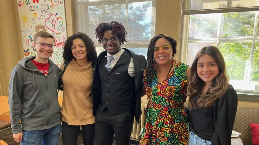Four students pose and smile with Dr. Ebony McGee in the IEDE Student Center