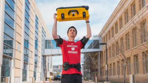 Tyler Bennett lifts a case overhead with help from an exoskeleton