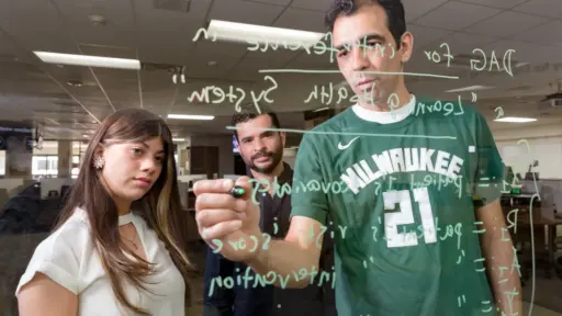 Assistant Professor Gabriel Zayas-Caban (right) works with PhD students Valerie Odeh-Couvertier (left) and Fernando Acosta-Perez.