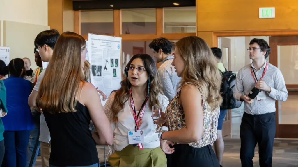 Graduate students network during a poster session.