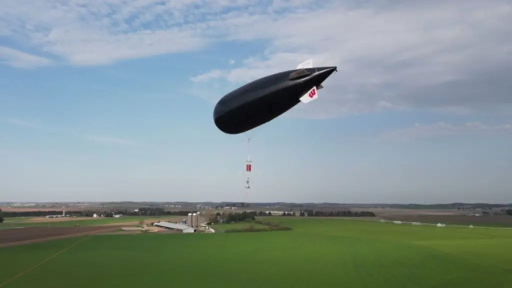 Black zeppelin balloon over farm