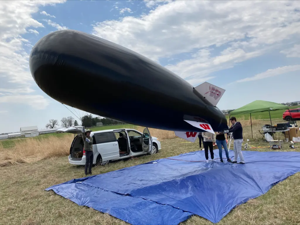 ECE students preparing black helium balloon for launch