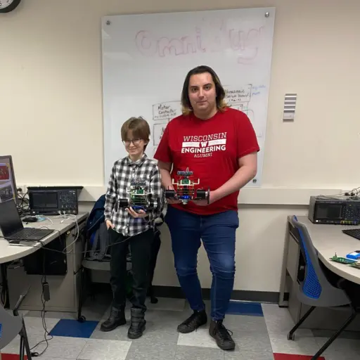 Two students holding Omni Bot projects