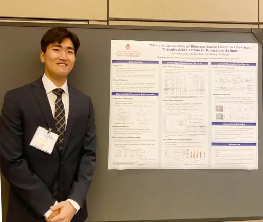 Kyuhyeok Choi, a undergraduate student, stands next to poster presentation.