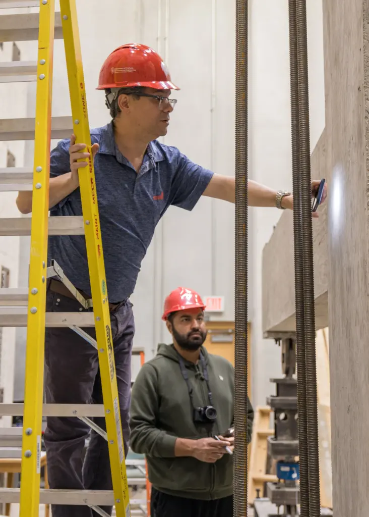 Professor Gustavo Parra-Montesinos looks at where a test column joins a beam during an experiment in the Jun and Sandy Lee Wisconsin Structures and Materials Testing Laboratory