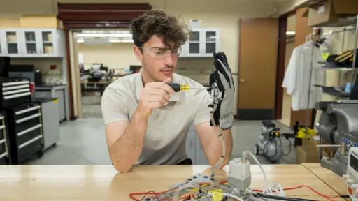 Student Ben Levy makes an adjustment to his haptic glove
