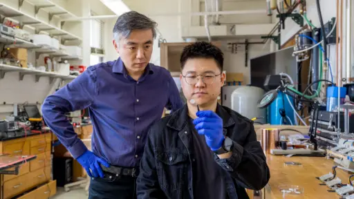 Xudong Wang and graduate student Wenjian Liu show off the dendrite-inhibiting membrane