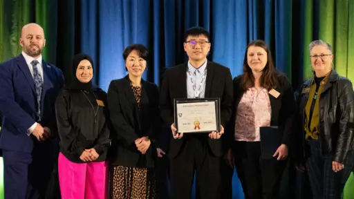 Xin Wang, pictured center, accepts a Best Paper Award from ASCE staff and others during the 2024 CI & CRC Joint Conference.