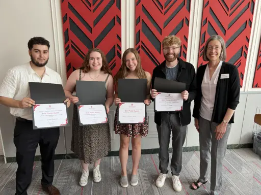 Students with certificates stand with Susan Hagness