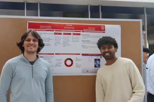 Two students in front of project poster