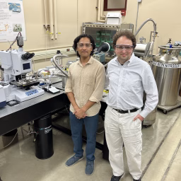 Tanuj Kumar and Mikhail Kats stand next to scientific equipment in a laboratory