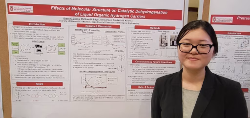 Student Grace Zhang next to research at poster session. Grace has long dark hair in a pony tail and is wearing glasses and a black blazer.
