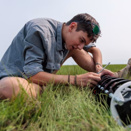 Soren Goldsmith checks on his camera in the field in Massachusetts