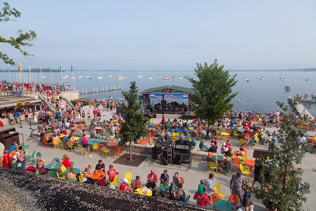 image of an outside terrace overlooking a lake, filled with people