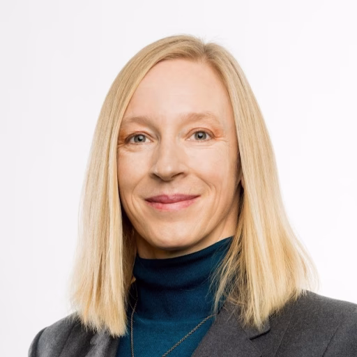 Blonde mid-career woman wearing a turtleneck and blazer
