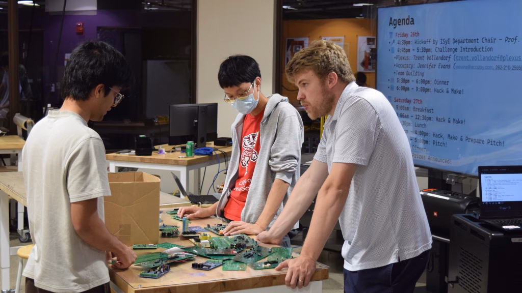 Assistant Professor Michael Biehler talks with students during the 2025 Hackathon/Makerthon.