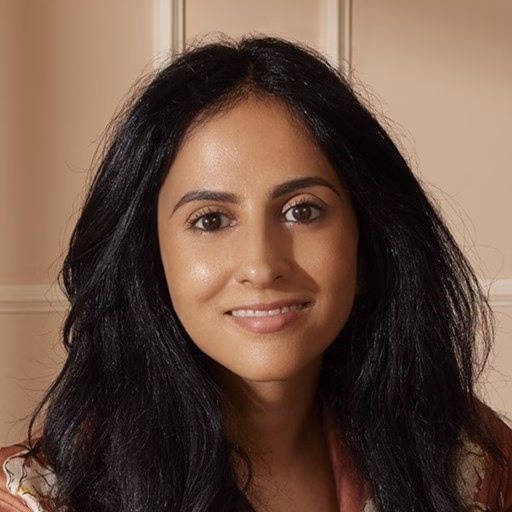 Woman with dark brown eyes and long brown hair smiling at the camera