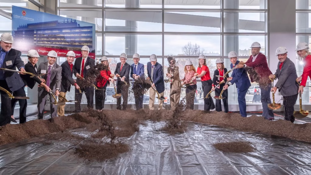 17 stakeholders tossing dirt with shovels for the new engineering building ground breaking ceremony