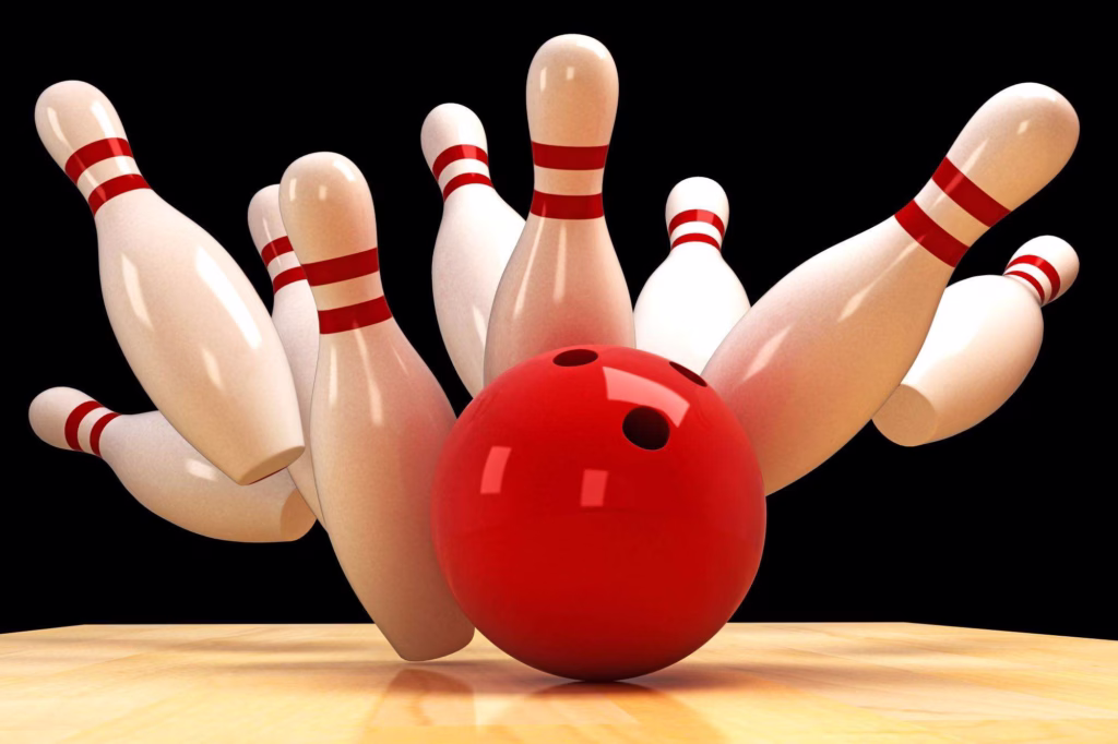 A red bowling ball knocking over bowling pins