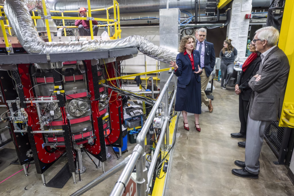 Assistant Professor Stephanie Diem explains research taking place with the Pegasus-III experiment to Governor Evers