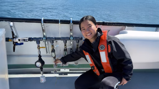 PhD student Ziyan Wu shows a boat’s sequential filtration system while collecting samples from Lake Michigan