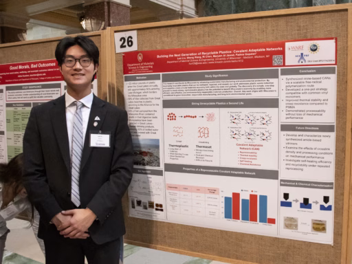 materials science and engineering senior Leo Liu stands next to his research poster at Research in the Rotunda