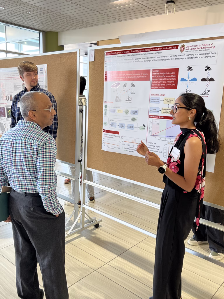 Parmesh talking with student presenting a research poster