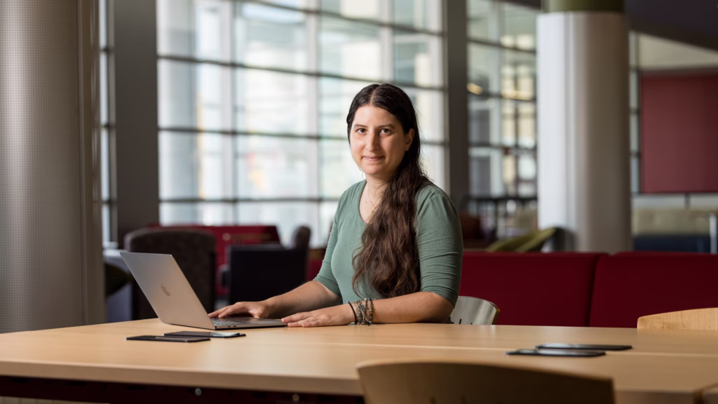 Styliana Avraamidou sits at table with laptop