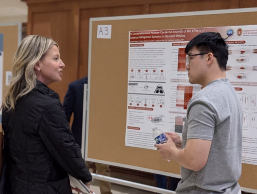 student and advisory board member discuss his poster.