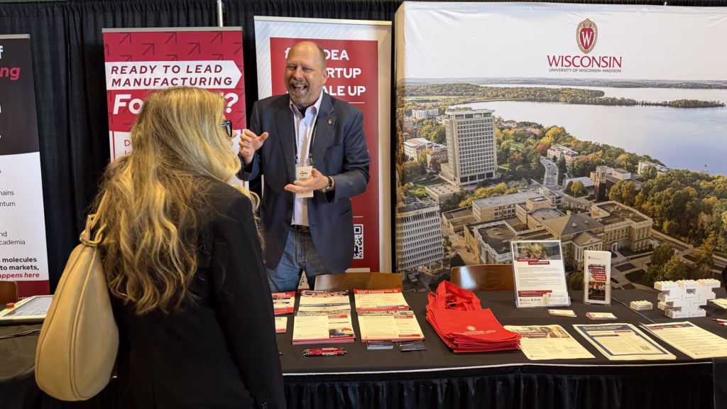 Mechanical Engineering Professor Frank Pfefferkorn speaks with an attendee at the Wisconsin Drives Manufacturing Summit on June 1, 2026 at Lambeau Field