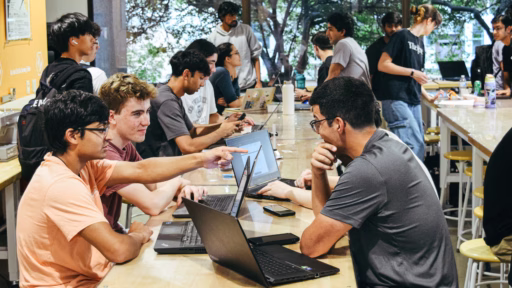 College of Engineering undergrad students at a table working on laptops during a hackathon event