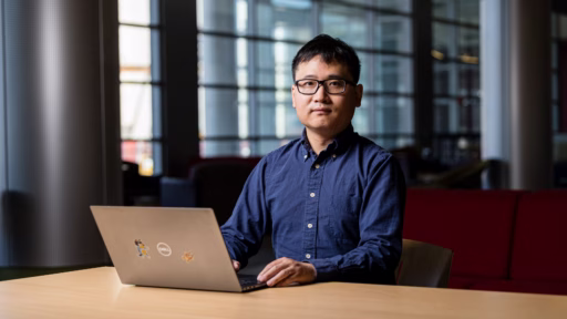 Haoran Wei at a table with a laptop