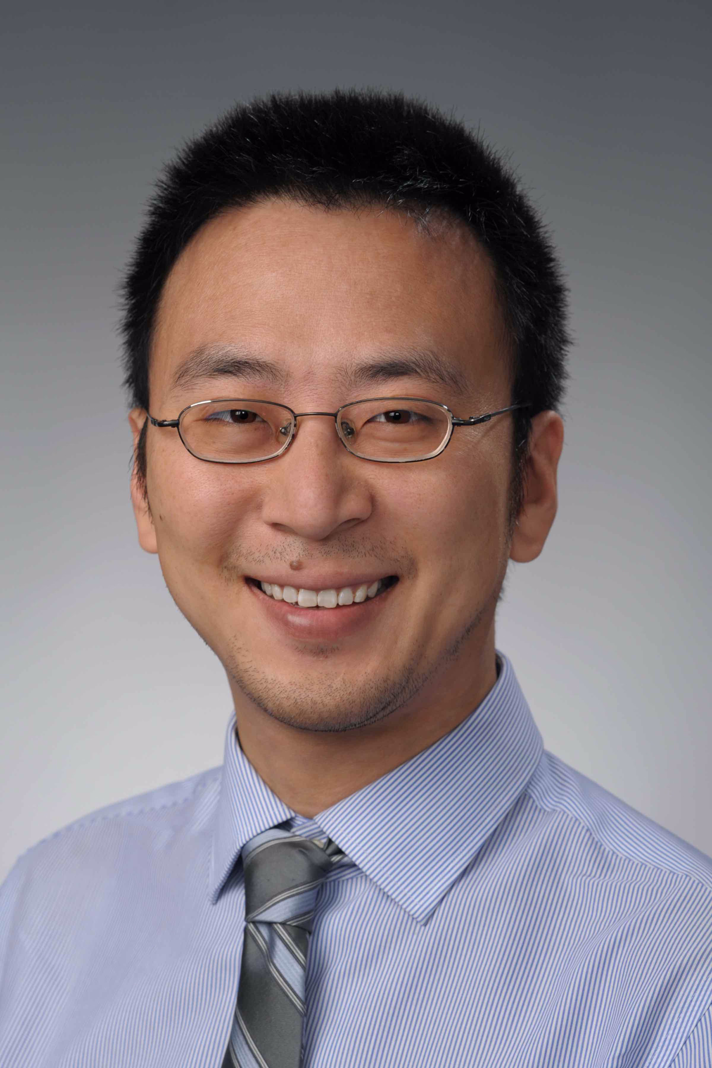 Profile photo of Zhen Ma. He has short dark hair and is wearing a blue shit and tie.