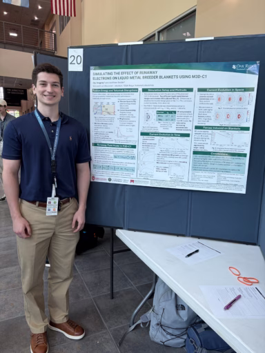 Undergraduate engineering physics student Jay Dregney stands next to his poster while presenting about the research he did during his internship at Oak Ridge National Laboratory.